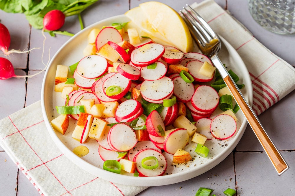 Radieschen-Apfel-Salat auf einem Teller mit einer Gabel.